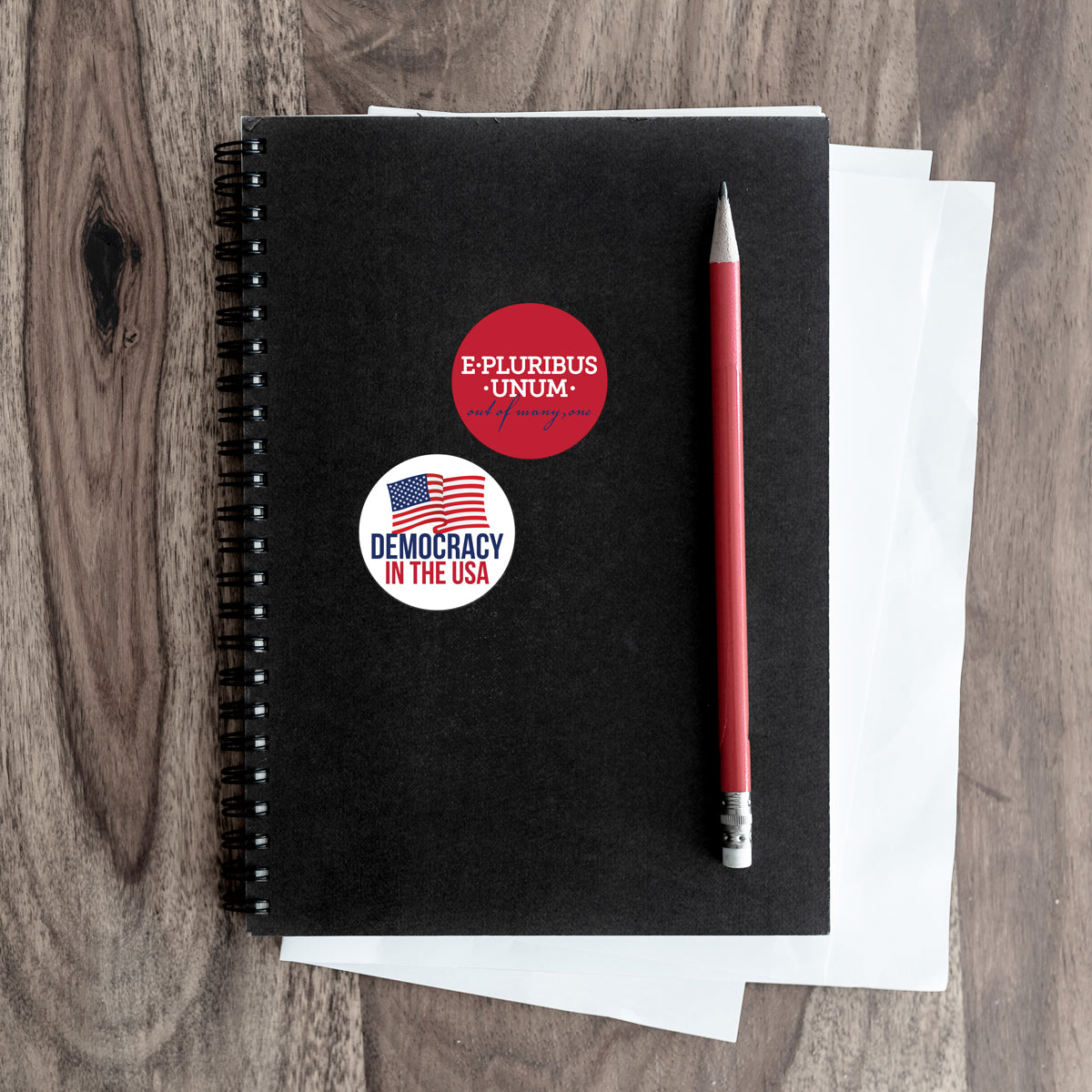 e pluribus and democracy stickers on a notebook
